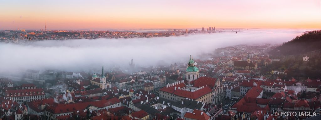 Blick von der Prager Burg ber das vernebelte Prag bei Sonnenuntergang