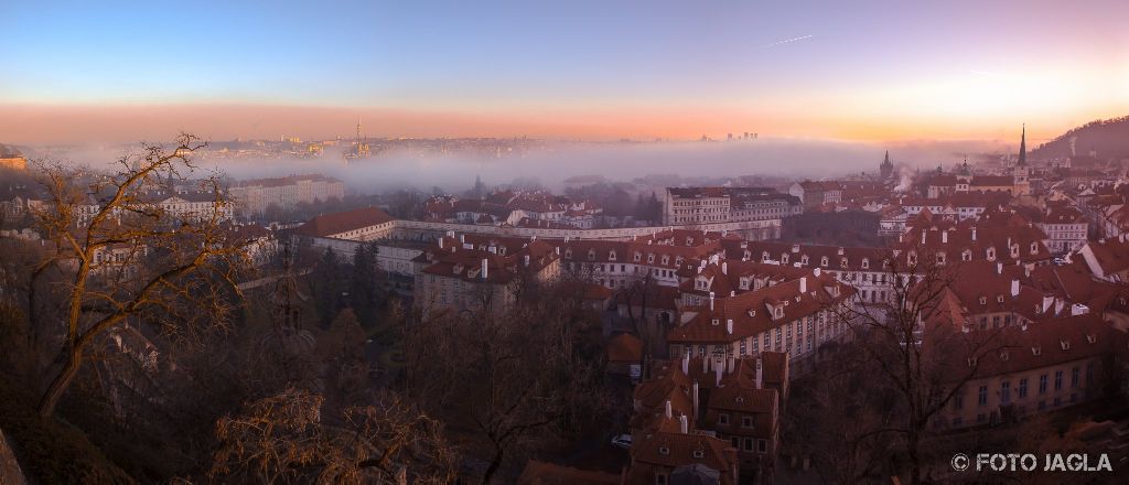 Blick von der Prager Burg ber das vernebelte Prag bei Sonnenuntergang