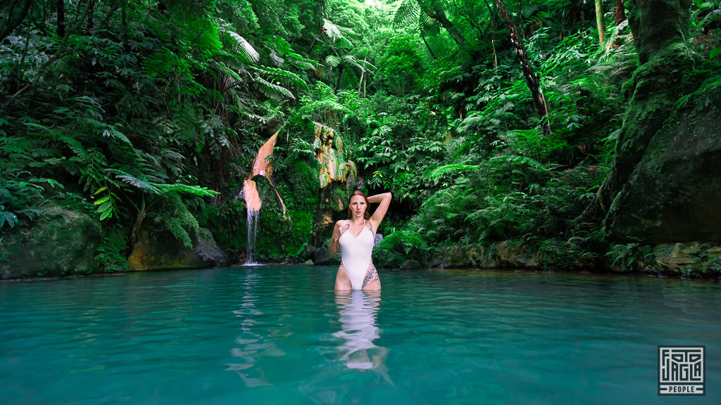Sexy Fotoshooting im weißen Badeanzug im Naturschwimmbecken mit Wasserfall im Naturdenkmal Caldeira Velha auf der Insel São Miguel auf den Azoren