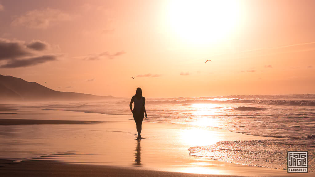 Sexy Frau im Badeanzug bei Sonnenuntergang am Strand von Playa de Cofete in Fuerteventura in Spanien