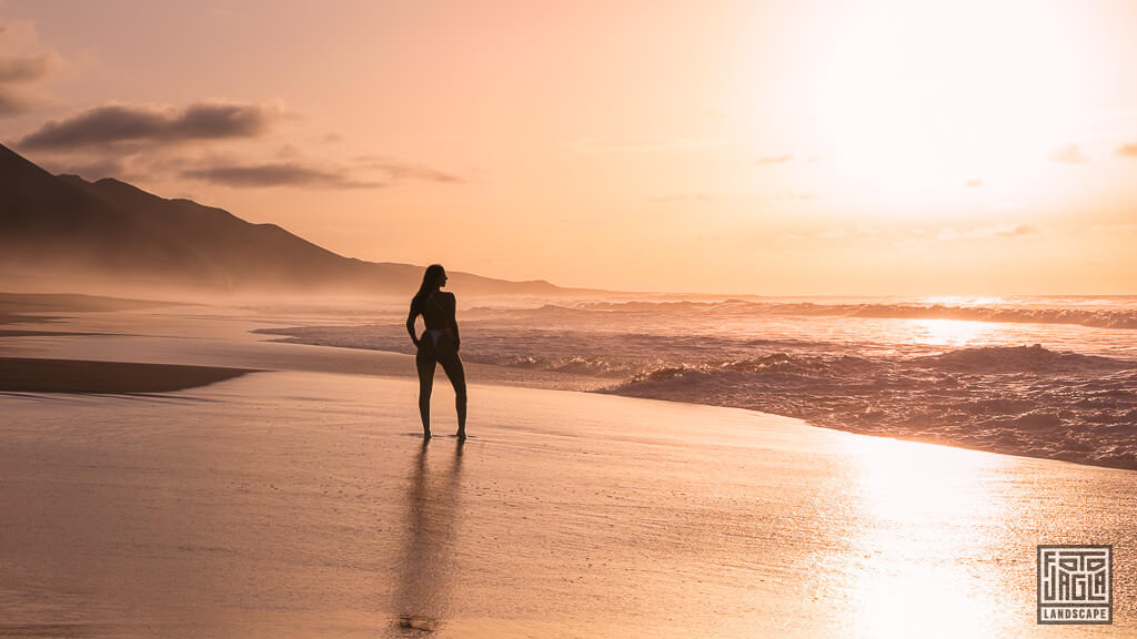 Sexy Frau im Badeanzug bei Sonnenuntergang am Strand von Playa de Cofete in Fuerteventura in Spanien